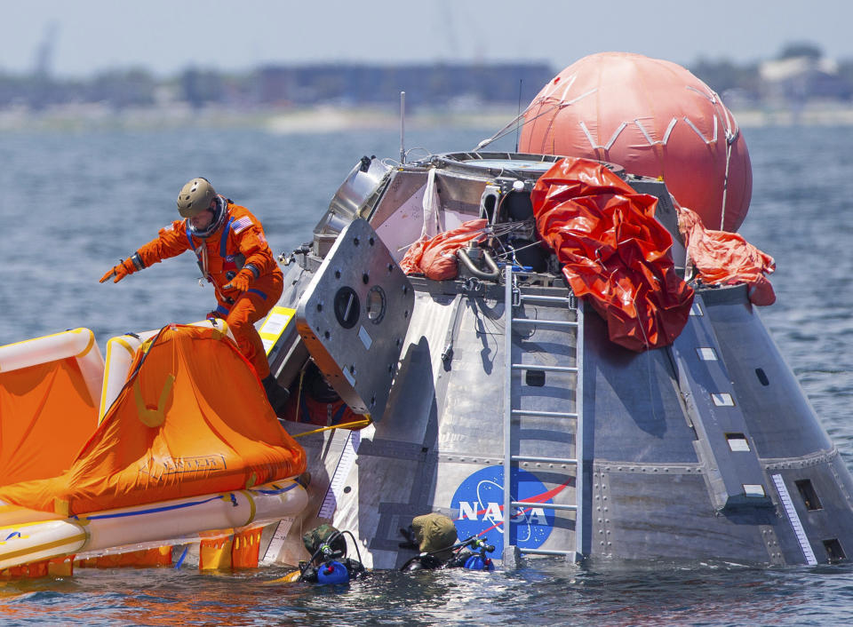FILE - In this July 13, 2017, file photo, NASA astronaut Mike Fincke jumps into a life raft from an Orion capsule the astronauts are using for a recovery test about four miles off of Galveston Island, Texas in the Gulf of Mexico, the first time since the Apollo program that NASA has practiced such egress techniques from a capsule in open water. Astronaut safety is paramount in getting to the moon, according to NASA Administrator Jim Bridenstine. But speed and cost are close seconds. By moving up the target lunar landing date from 2028 to 2024, NASA hopes to retire as much political risk as possible by getting out of the gate fast. (Mark Mulligan/Houston Chronicle via AP, File)