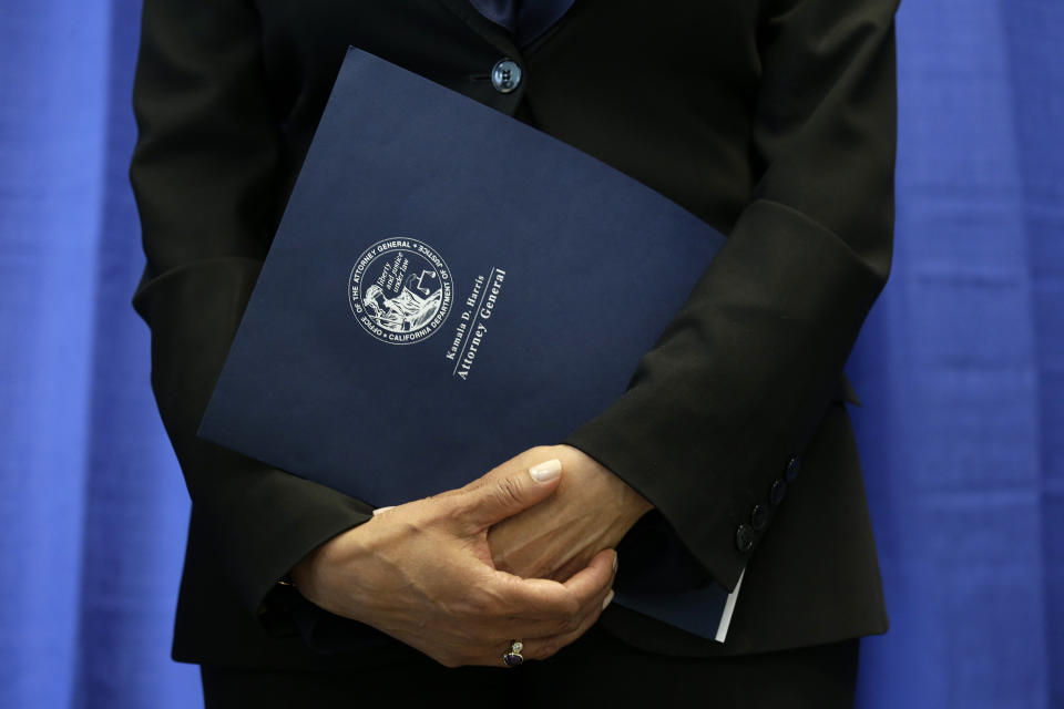 FILE - In this June 28, 2016, file photo California Attorney General Kamala Harris holds her notes and statement about a settlement with Volkswagen during a news conference in San Francisco. (AP Photo/Eric Risberg, File)