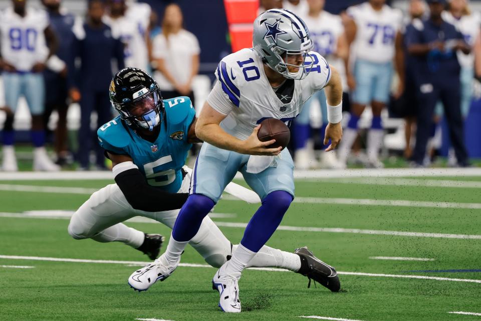 Dallas Cowboys quarterback Cooper Rush (10) runs the ball against Jacksonville Jaguars safety Andre Cisco (5) during the first half of an NFL preseason football game, Saturday, Aug. 12, 2023, in Arlington, Texas. (AP Photo/Michael Ainsworth)