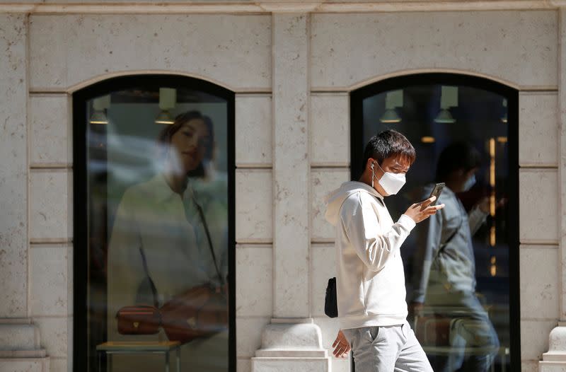 FILE PHOTO: A man wearing a face mask walks in downtown Lisbon