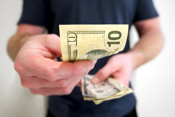 Man holding 10-dollar bills