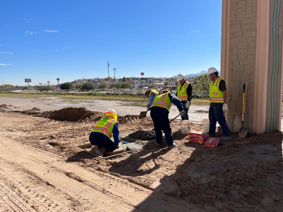 An El Paso Water maintenance crew works on the manhole cover that spilled untreated wastewater in the Rio Grande flood plain near UTEP.