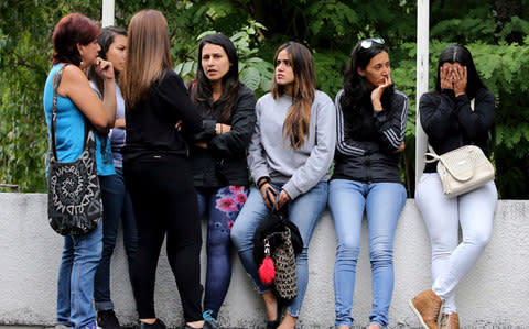 Women related to men who fought alongside the late, rebel police officer Oscar Perez wait for their loved ones' bodies to be turned over, outside the morgue in Caracas - Credit: AP Photo/Fernando Llano