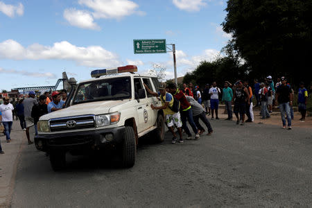 FILE PHOTO: An ambulance carrying people that were injured during clashes in the southern Venezuelan town of Kumarakapay, near the border with Brazil, is assisted by people at the border between Venezuela and Brazil, in Pacaraima, Roraima state, Brazil February 22, 2019. REUTERS/Ricardo Moraes/File Photo