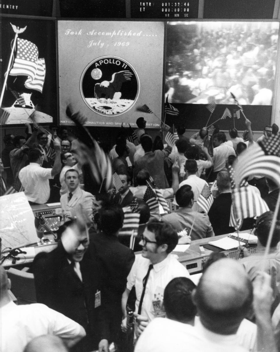 Overall view of the Mission Operations Control Room in the Mission Control Center, Building 30, Manned Spacecraft Center, showing the flight controllers celebrating the successful conclusion of the Apollo 11 lunar landing mission. | Bettmann/Corbis/Getty Images