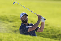 Jon Rahm, of Spain, watches after hitting out of a bunker on the 17th hole of the South Course at Torrey Pines during the third round of the Farmers Insurance Open golf tournament, Friday, Jan. 27, 2023, in San Diego. (AP Photo/Gregory Bull)