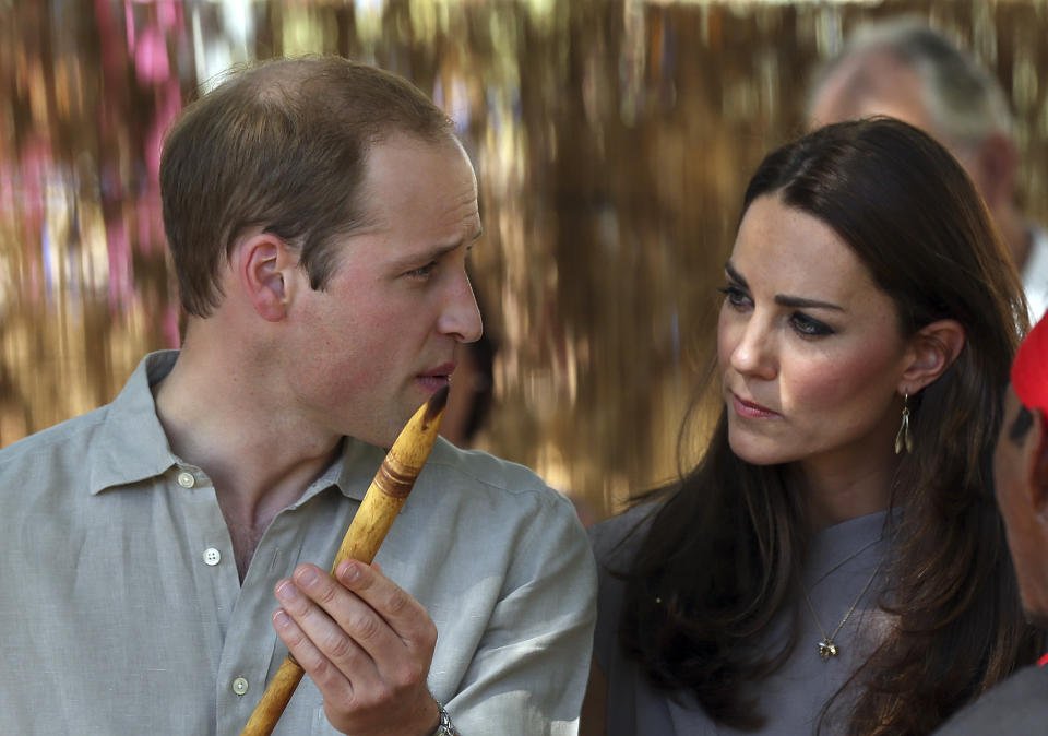 Britain's Prince William holds a ceremonial spear given to him as he talks with his wife Kate, the Duchess of Cambridge. after they arrived at the National Indigenous Training Academy at Yulara, near Uluru, Australia, Tuesday, April 22, 2014. (AP Photo/Rob Griffith)