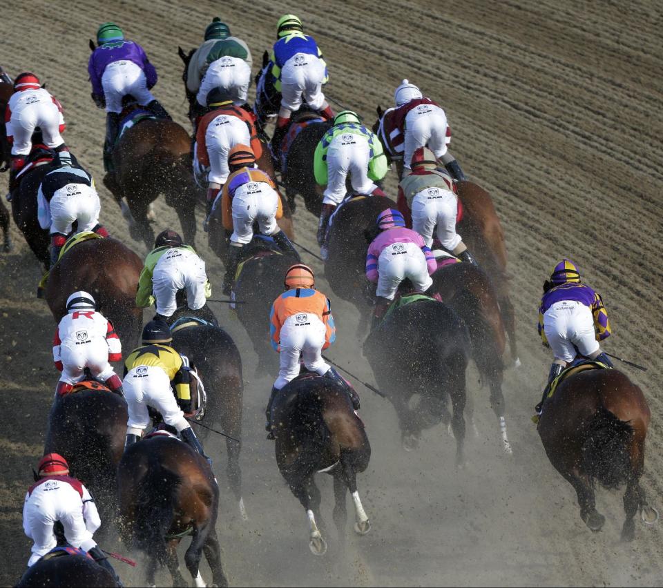 Horses make their way around turn one during the 140th running of the Kentucky Derby horse race at Churchill Downs Saturday, May 3, 2014, in Louisville, Ky. (AP Photo/Charlie Riedel)