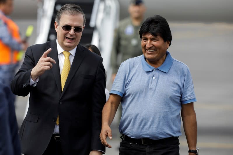 Bolivia's ousted President Evo Morales is welcomed by Mexico's Foreign Minister Marcelo Ebrard during his arrival to take asylum in Mexico, in Mexico City