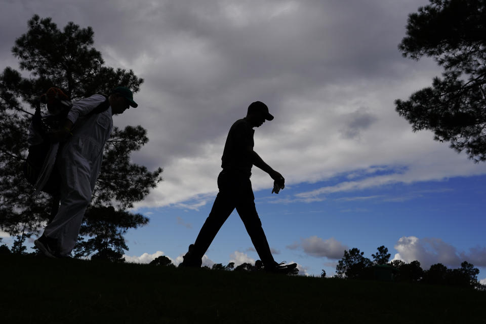 Tiger Woods walks down the 18th fairway with his caddie during the first round of the Masters golf tournament Thursday, Nov. 12, 2020, in Augusta, Ga. (AP Photo/Charlie Riedel)