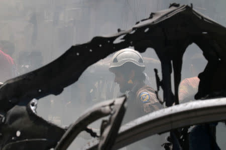 A Civil Defence member reacts in a damaged site near the frame of a burnt vehicle after an airstrike on al-Jalaa street in the rebel held city of Idlib, Syria. REUTERS/Ammar Abdullah