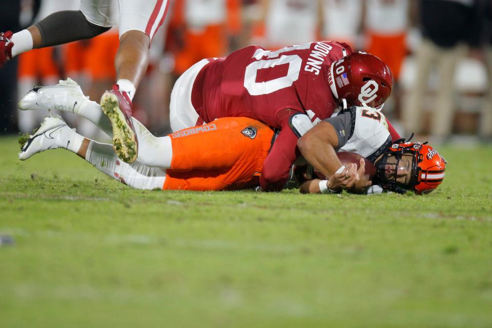 Oklahoma's Ethan Downs (40) brings down Oklahoma State's Spencer Sanders (3) during a Bedlam college football game between the University of Oklahoma Sooners (OU) and the Oklahoma State University Cowboys (OSU) at Gaylord Family-Oklahoma Memorial Stadium in Norman, Okla., Saturday, Nov. 19, 2022. 