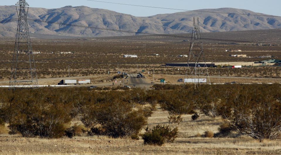 FILE - This photo Jan. 25, 2012, photo shows the site of a proposed station for a high-speed rail line to Las Vegas, foreground, with Interstate 15 in the background, on the far outskirts of Victorville, Calif., the Mojave Desert city on the route from Los Angeles to Las Vegas. Brightline West and U.S. transportation secretary and other officials projecting that millions of ticket-buyers will be boarding trains by 2028. (AP Photo/Reed Saxon)