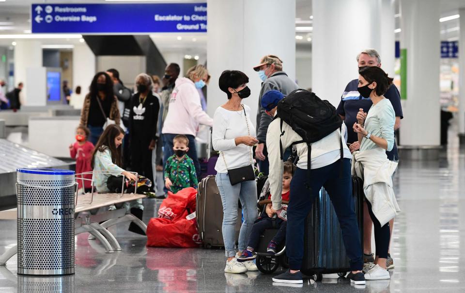 Travelers collect their luggage at the airport in Los Angeles on Nov. 23, 2021.