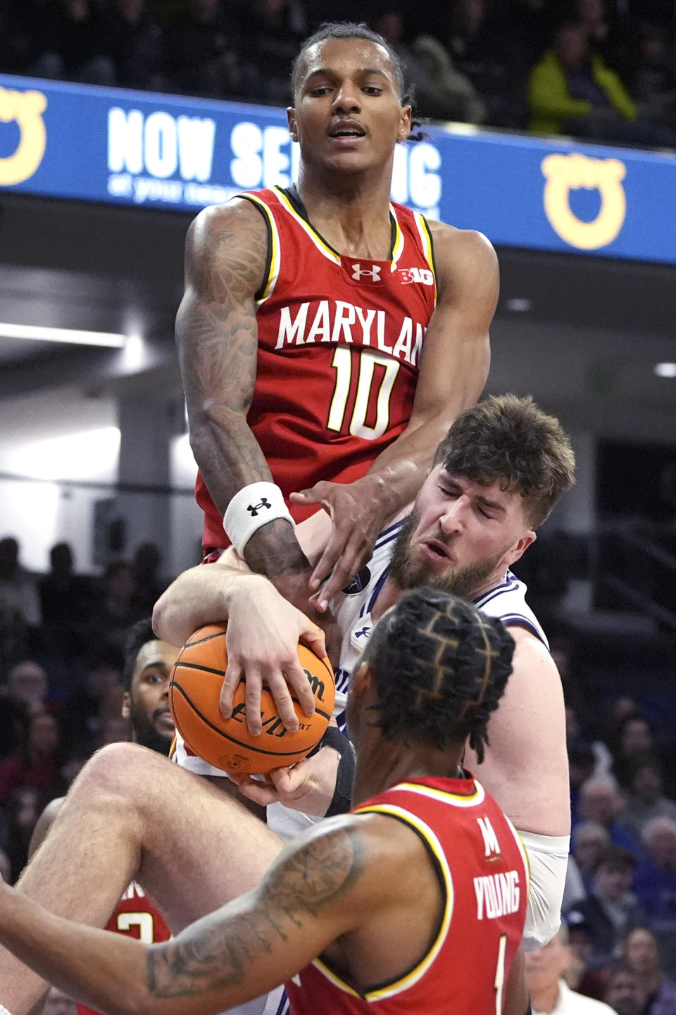 Northwestern center Matthew Nicholson vies for a rebound against Maryland forward Julian Reese, top, and guard Jahmir Young, foreground, during the second half of an NCAA college basketball game in Evanston, Ill., Wednesday, Jan. 17, 2024. (AP Photo/Nam Y. Huh)