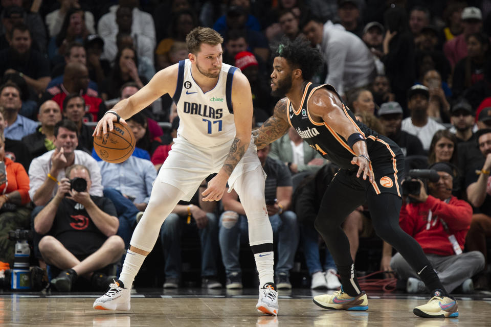 Dallas Mavericks guard Luka Doncic (77) dribbles against Atlanta Hawks forward Saddiq Bey during the first half of an NBA basketball game, Sunday, April 2, 2023, in Atlanta. (AP Photo/Hakim Wright Sr.)