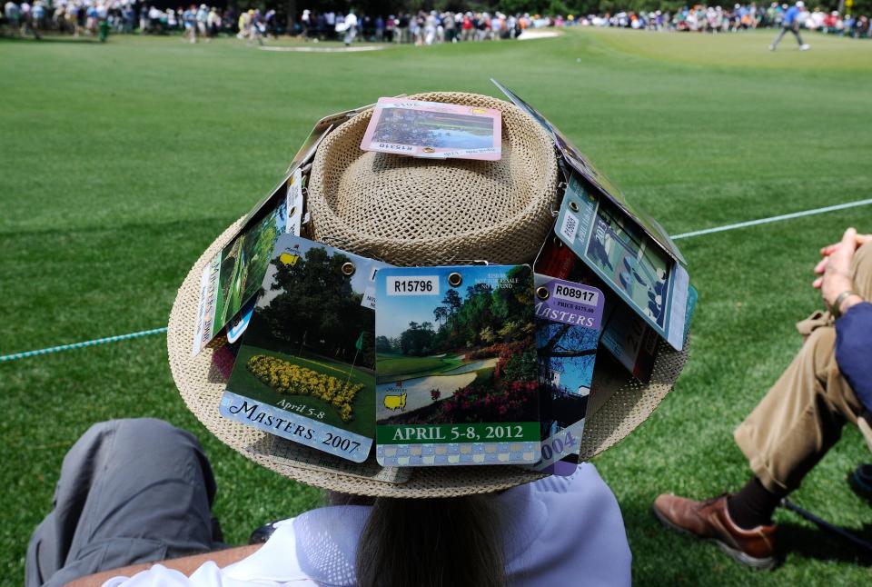 A fan decorated his hat with badges of Masters past.
