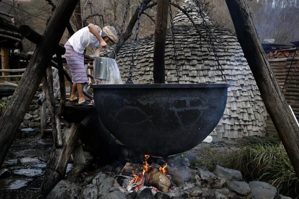 Bathhouse worker Alexander Bogatov prepares a hot pot at the British Banya bathhouse, Saturday, Feb. 15, 2014, in Krasnaya Polyana, Russia. Preparations begin late in the afternoon, at least three hours before the bathing party arrives. (AP Photo/Jae C. Hong)