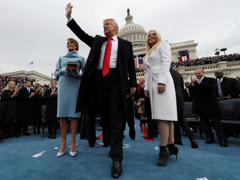 Inauguration - 20 January 2017: US President Donald Trump acknowledges the audience after taking the oath of office as his wife Melania (L) and daughter Tiffany watch during inauguration ceremonies swearing in Trump as the 45th president of the United States on the West Front of the US capital in Washington on 20 January, 2017. Photographer Jim Bourg: 