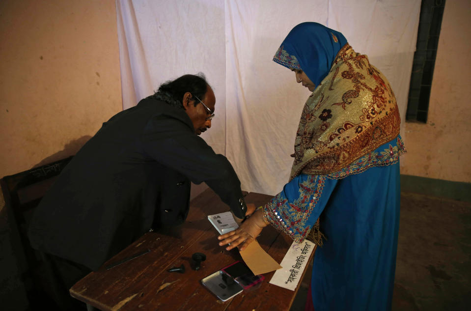 A Bangladeshi woman puts her thumb print to receive a ballot paper before casting her vote at a polling station in Dhaka, Bangladesh, Sunday, Jan. 5, 2014. Voting has started in Bangladesh for general elections Sunday that threaten to deepen the crisis in the South Asian nation. The opposition and its allies are boycotting the vote, a move that undermines the legitimacy of the election and makes it unlikely that the polls will stem a wave of political violence that killed at least 275 people in 2013. (AP Photo/ Rajesh Kumar Singh)