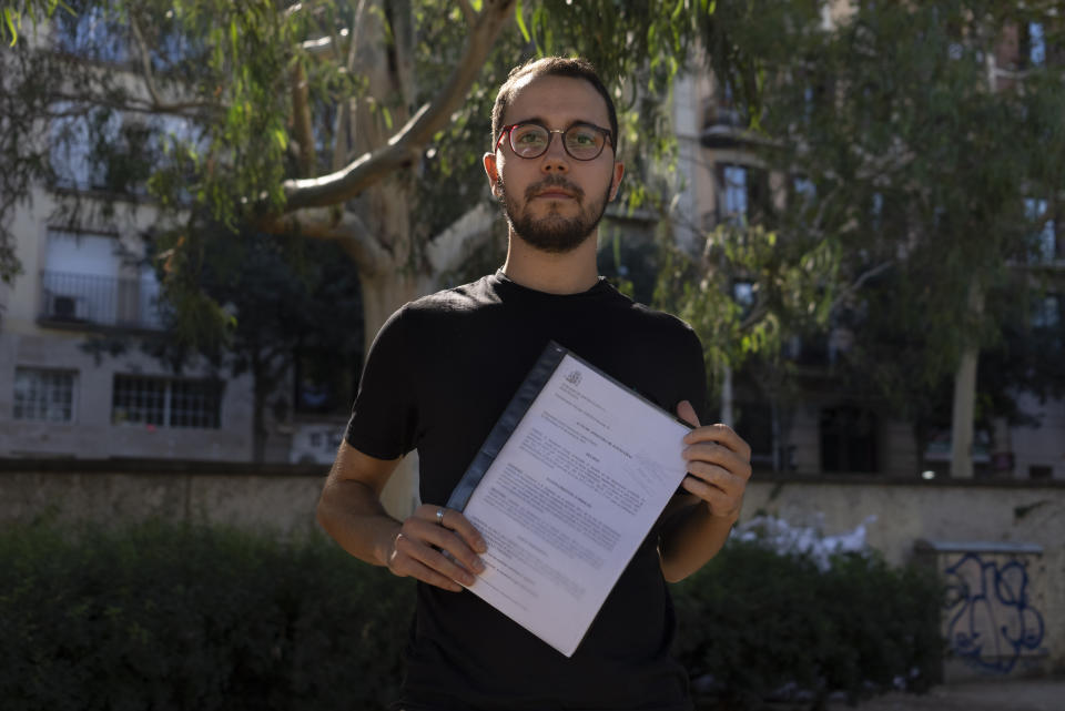 Oriol Calvo poses for a portrait holding court documents in Barcelona, Sept. 30, 2023. Calvo is among several thousand average citizens who face legal trouble for their often tiny part in Catalonia's illegal and failed independence bid that brought Spain to the brink of rupture six years ago. Now this 25-year-old accountant from Barcelona hopes his conviction will be wiped clean if Spain's acting prime minister Pedro Sanchez follows through and issues a sweeping amnesty for the separatists in exchange for their movement's political parties helping him form a new government in Madrid. (AP Photo/Renata Brito)