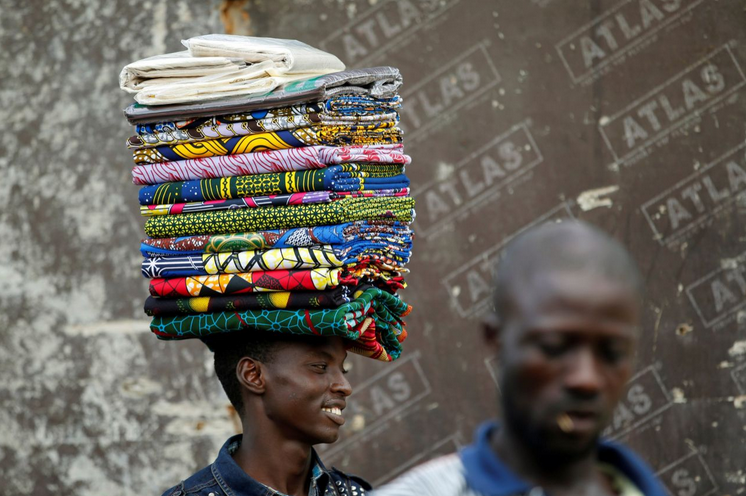 Ein Textilverkäufer in Lagos, Nigeria, hofft auf zahlende Kunden. (Photo: Akintunde Akinleye/Reuters)