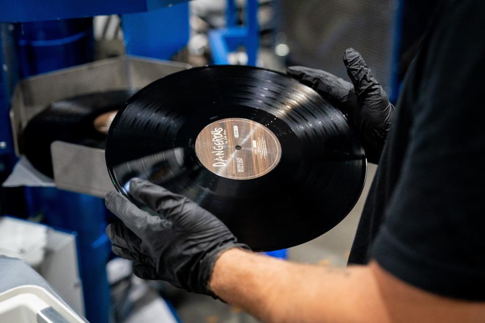 Press operator Christopher Whitehead checks vinyl records as they come out of the pressing machine at Nashville Record Pressing in Nashville, Tenn., Thursday, July 7, 2022.