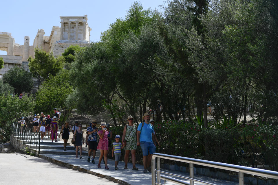 Tourists exit the ancient Acropolis, in Athens Greece, Tuesday, Aug. 3, 2021. Authorities in Greece have closed the Acropolis and other ancient sites during afternoon hours as a heatwave scorching the eastern Mediterranean continued to worsen. Temperatures reached 42 C (107.6 F) in parts of the Greek capital, as the extreme weather fueled deadly wildfires in Turkey and blazes across the region. (AP Photo/Michael Varaklas)