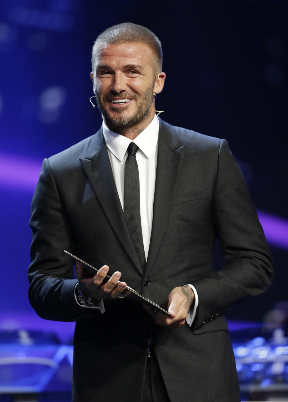 UEFA President's Award winner David Beckham smiles on stage during for the UEFA Champions League draw at the Grimaldi Forum, in Monaco, Thursday, Aug. 30, 2018. (AP Photo/Claude Paris)