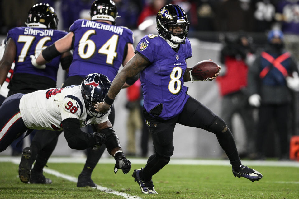 Baltimore Ravens quarterback Lamar Jackson (8) runs from Houston Texans defensive tackle Sheldon Rankins (98) during the first half of an NFL football AFC divisional playoff game, Saturday, Jan. 20, 2024, in Baltimore. (AP Photo/Nick Wass)