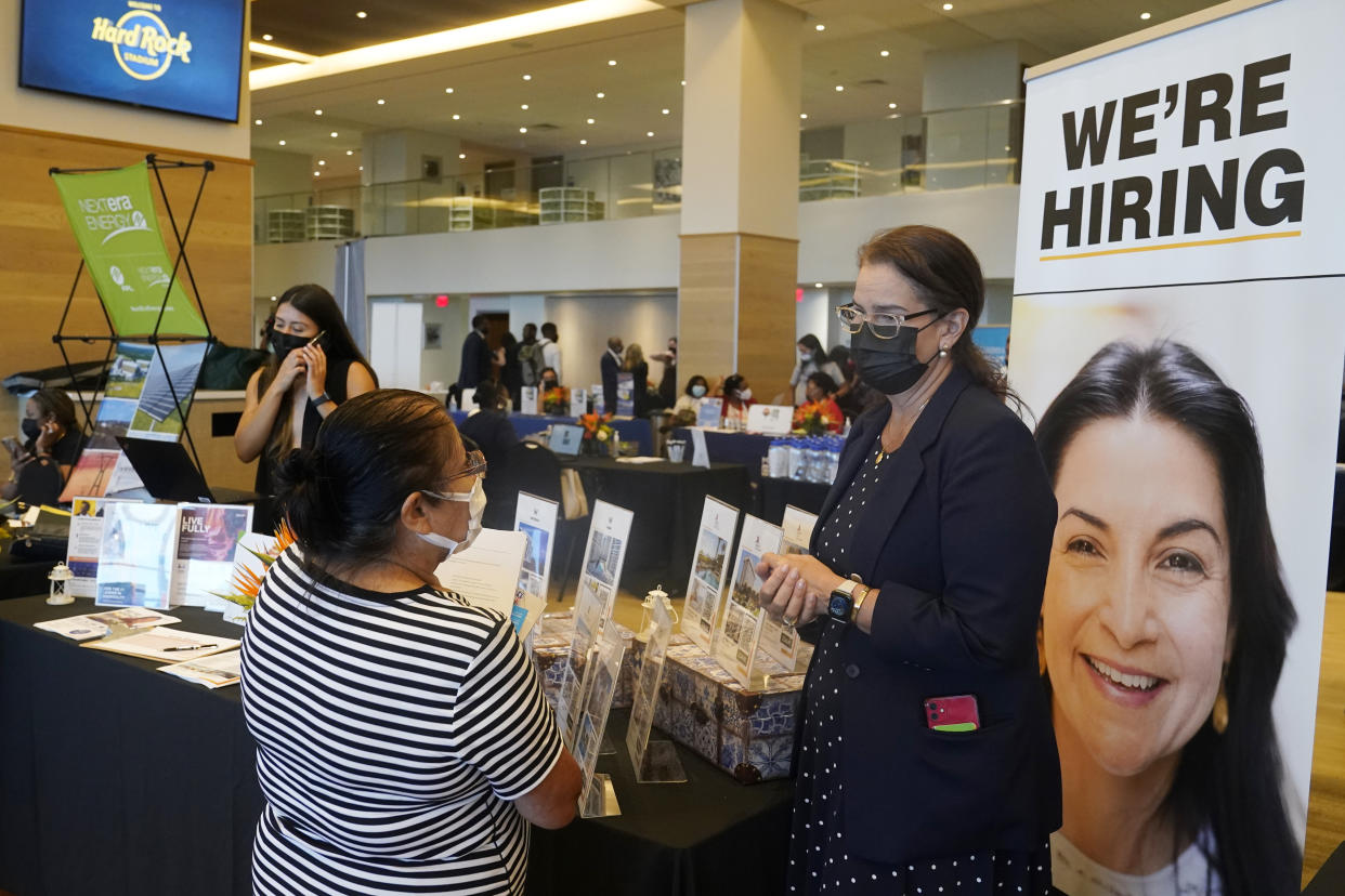 FILE - Marriott human resources recruiter Mariela Cuevas, left, talks to Lisbet Oliveros, during a job fair at Hard Rock Stadium, Friday, Sept. 3, 2021, in Miami Gardens, Fla. Americans quit their jobs at a record pace for the second straight month in September, while businesses and other employers continued to post a near-record number of available jobs. (AP Photo/Marta Lavandier, File)