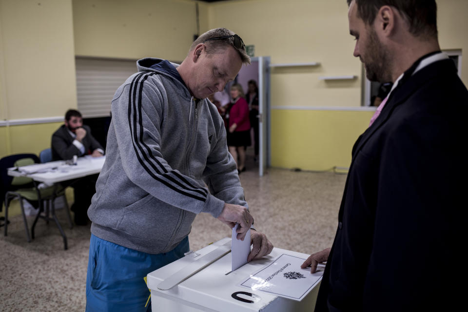 A man places his vote during general elections in Gibraltar, Thursday Oct. 17, 2019. An election for Gibraltar's 17-seat parliament is taking place Thursday under a cloud of uncertainty about what Brexit will bring for this British territory on Spain's southern tip.(AP Photo/Javier Fergo)