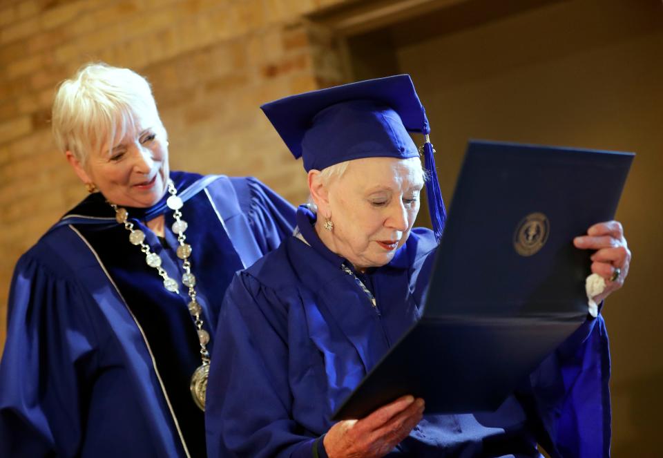 Rosemary Lloyd, 88, of Appleton checks out her bachelor's degree from Marian University on Nov. 9 in Appleton. Behind Lloyd is Marian University president Michelle Majewski.