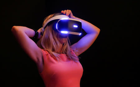 A woman tries on earphones and a headset used for virtual reality at the Venice Virtual Reality a competition during 74th Venice Film Festival in Venice, Italy, August 29, 2017. REUTERS/Alessandro Bianchi