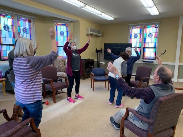 Racheal Braeunig, center, leads participants at the Wooster Memory Café through various exercises. Braeunig works with the Danbury Senior Living location in Wooster and helps out with the Memory Café regularly. A cafe will open in Orrville later this month.