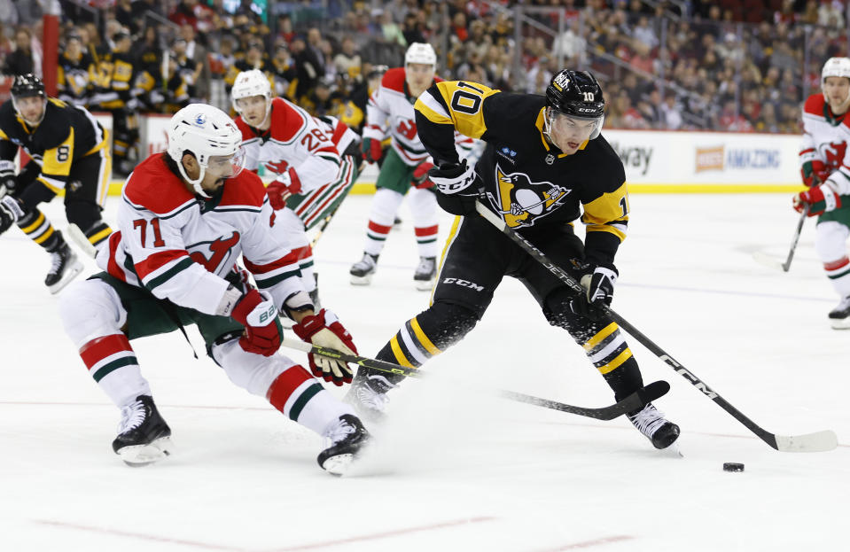 Pittsburgh Penguins left wing Drew O'Connor (10) plays the puck against New Jersey Devils defenseman Jonas Siegenthaler (71) during the first period of an NHL hockey game Tuesday, April 4, 2023, in Newark, N.J. (AP Photo/Noah K. Murray)