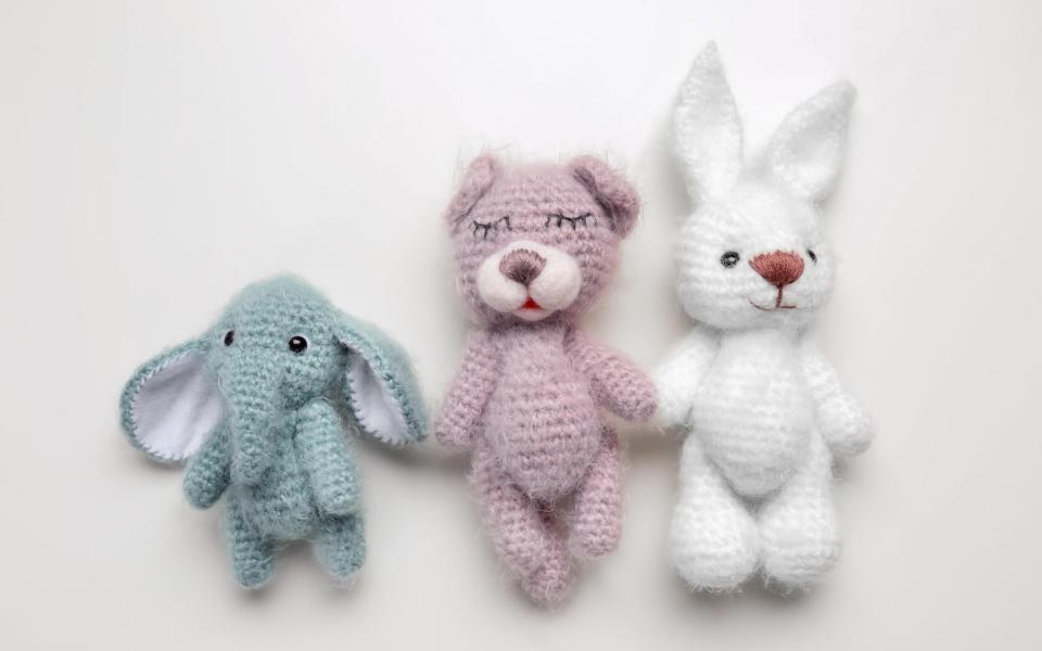 Handmade knitted baby toys isolated on white - Alamy Stock Photo