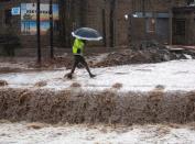 Man crosses a flooded bridge in kwaNdengezi