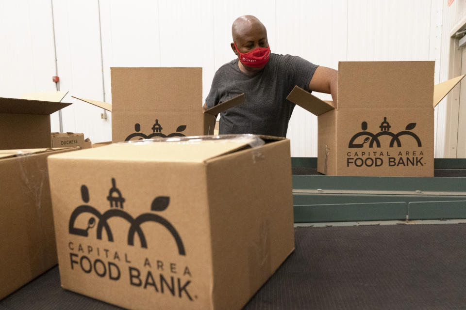 FILE - A volunteer pack boxes of food for distribution, at The Capital Area Food Bank on Oct. 5, 2021, in Washington. As the country’s food charities struggle to keep up with rising inflation and demand, the White House will host a conference on Wednesday, Sept. 28, 2022. For several months, the Biden administration has hosted listening sessions with hunger and nutrition groups, corporations, and federal agencies to help find ways to end hunger by 2030. (AP Photo/Jacquelyn Martin, File)