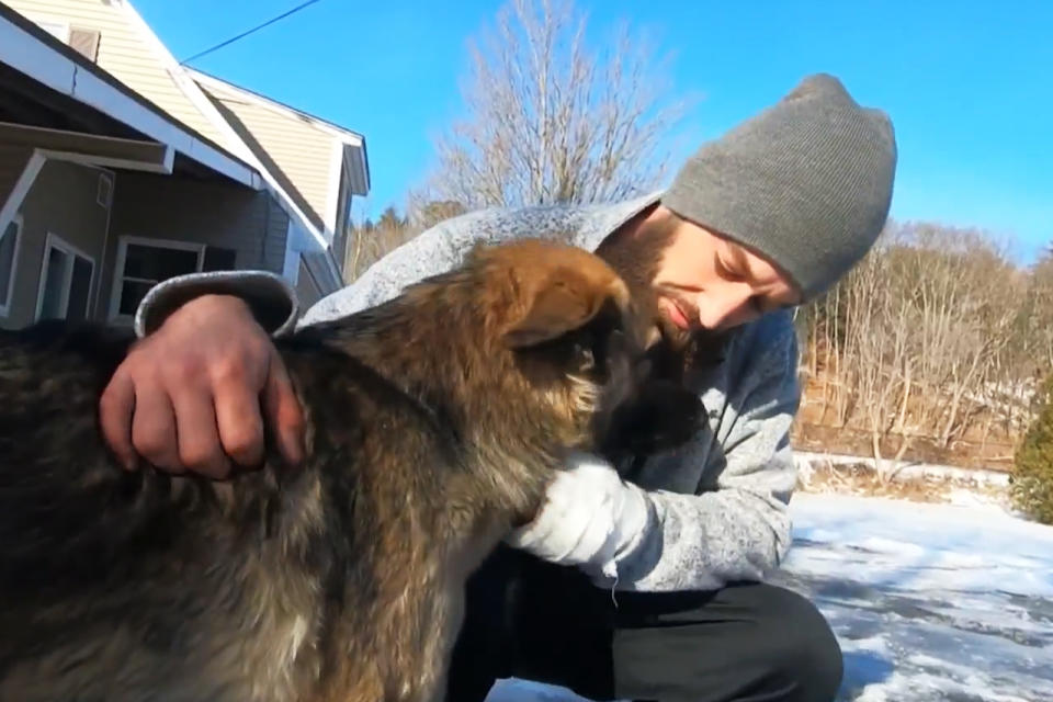 Cam Laundry hugs his dog Tinsley, who saved him from a crash in Vermont by leading police to where he was thrown from his vehicle. (WBTS)