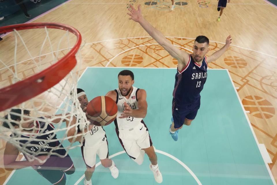 American Stephen Curry passes Serbian Ognjen Dobric during a semifinal basketball game