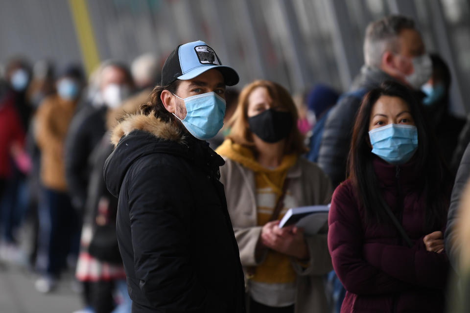 People are seen waiting in line at the Melbourne Convention and Exhibition Centre vaccination clinic in Melbourne. Source: AAP