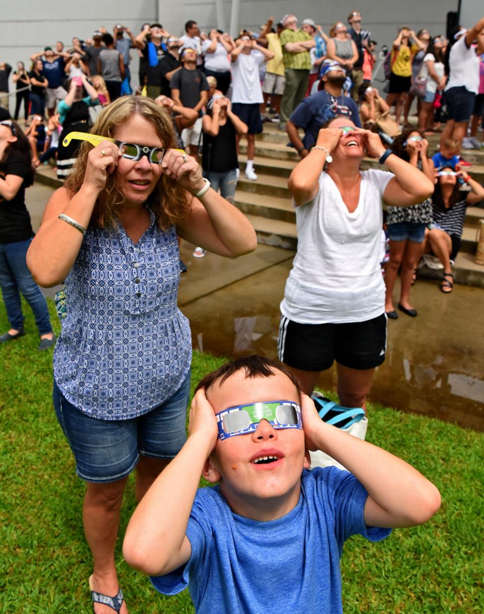 At 2:47pm a break in the clouds gave Ben Levinson, his mom Amy Levinson (at left) and friend Mary Hayford the chance to use their glasses and see the eclipse at totality for our area. On Monday August 21, 2017 the UNF Physics Department, Student Union and Office of Campus Life hosted an eclipse viewing party 1:30 to 3:30 p.m. Monday, Aug. 21, at Coxwell Amphitheater, near the Student Union on the campus of the University of North Florida. (Bob Mack/Florida Times-Union)