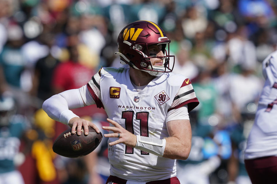 Washington Commanders quarterback Carson Wentz (11) looking to pass the ball against the Philadelphia Eagles during the first half of an NFL football game, Sunday, Sept. 25, 2022, in Landover, Md. (AP Photo/Susan Walsh)