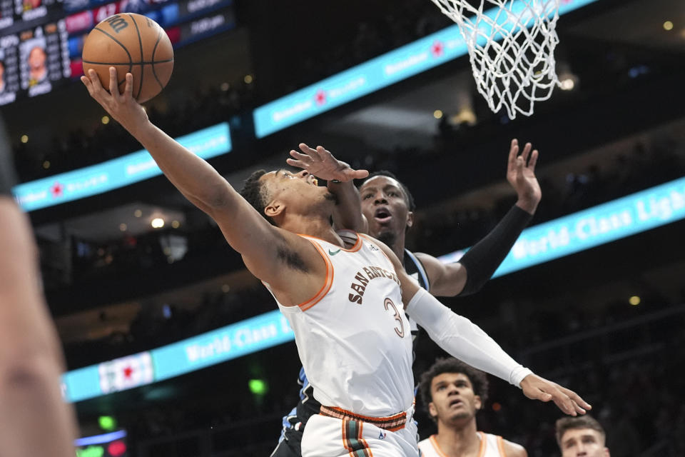 San Antonio Spurs forward Keldon Johnson (3) shoots as Atlanta Hawks forward Onyeka Okongwu (17) defends during the first half of an NBA basketball game Monday, Jan. 15, 2024, in Atlanta. (AP Photo/John Bazemore)