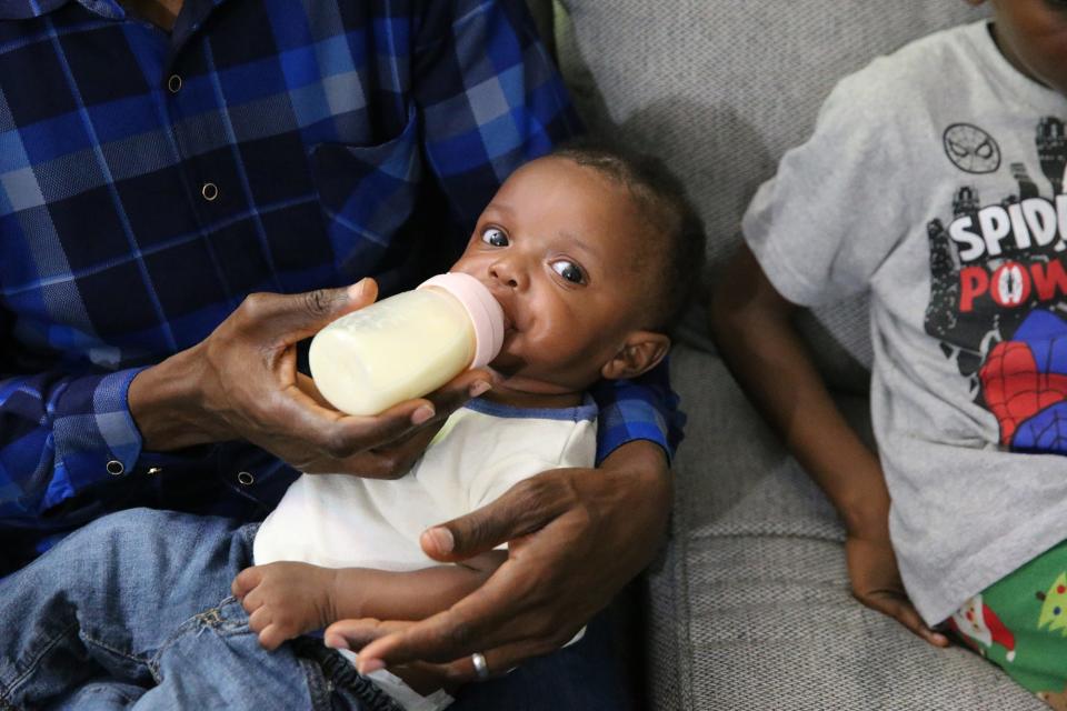 Abel Nimi feeds his 4-month-old son, Joseph, at their Sanford apartment. He and his family are from Angola and are asylum seekers. Joseph is officially a United States citizen since he was born here shortly after the family arrived.