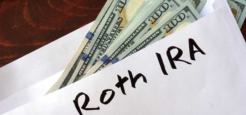 Envelope labeled ROTH IRA filled with cash.