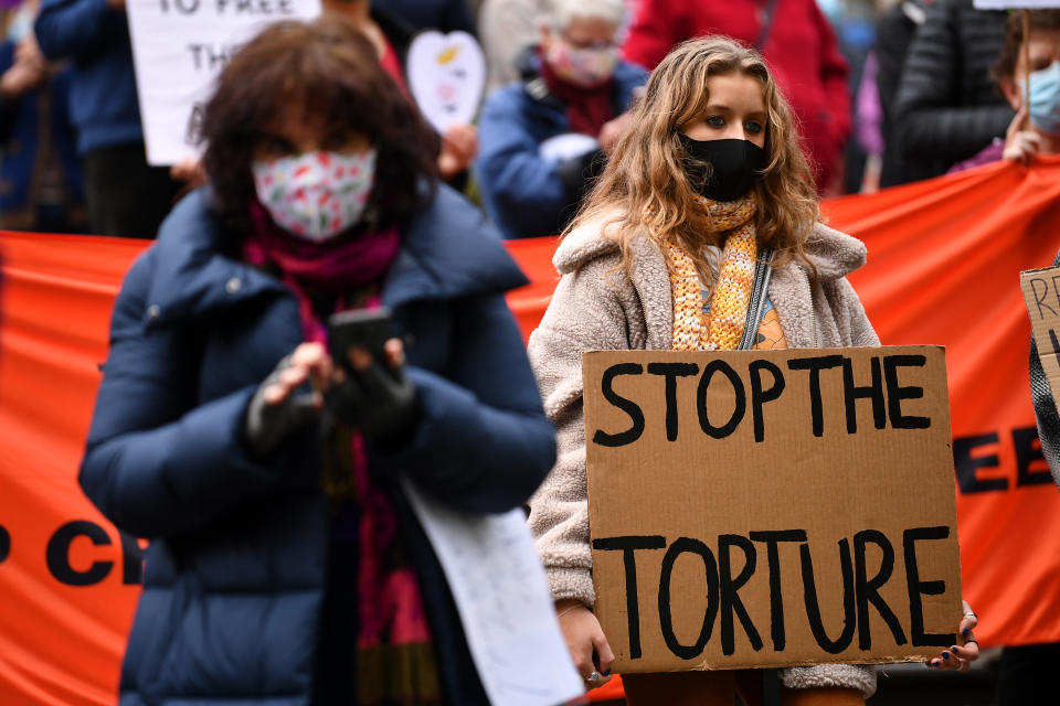 A woman holds a sign reading 'Stop The Torture' at a supporters rally. Source: AAP