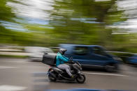 A delivery worker rides his motorbike in Madrid, Spain, Tuesday, May 11, 2021. Spain has approved a pioneering law that gives delivery platforms a mid-August deadline to hire the workers currently freelancing for them and that requires transparency of artificial intelligence to manage workforces. (AP Photo/Manu Fernandez)
