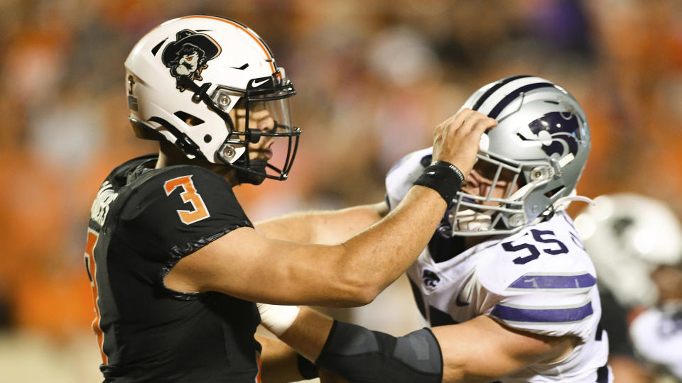 Oklahoma State quarterback Spencer Sanders (3) defends against a tackle by Kansas State linebacker Cody Fletcher (55) following a pass, during an NCAA college football game Saturday, Sept. 25, 2021, in Stillwater, Okla. (AP Photo/Brody Schmidt)